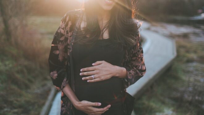 Pregnant woman outside in sunset