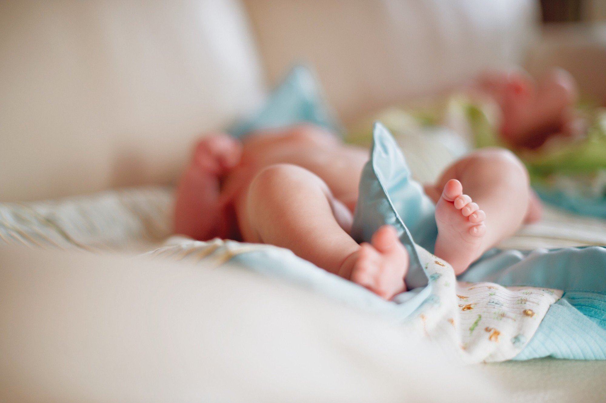 Newborn baby boy laying on bed