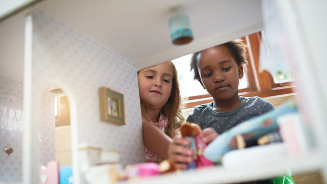 Two girls playing dollhouse