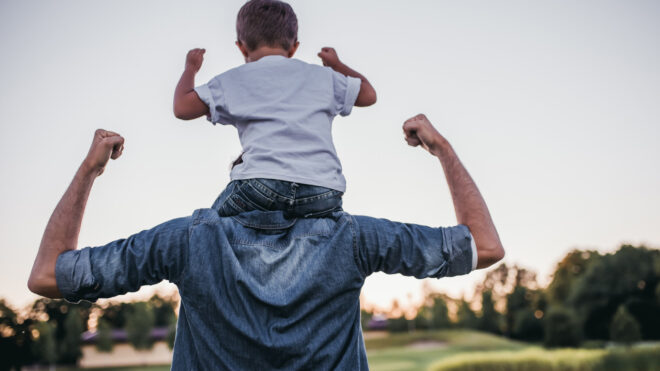 Boy sits on dad's shoulders