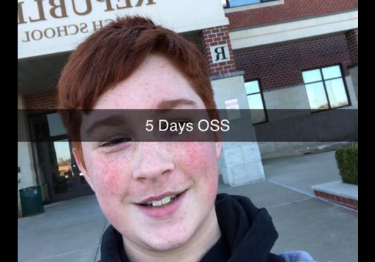 Boy standing in front of school.