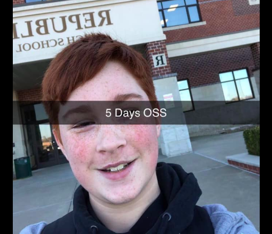 Boy standing in front of school.