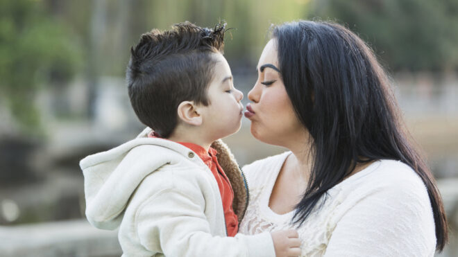 mom kissing kid on lips