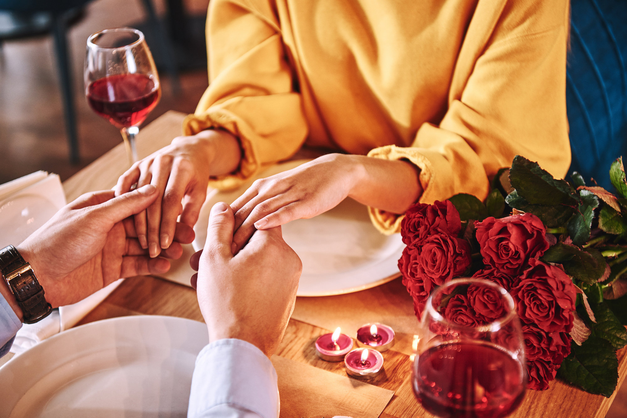 Romantic moments. Young man holding hands of his girlfriend in restaurant stock photo