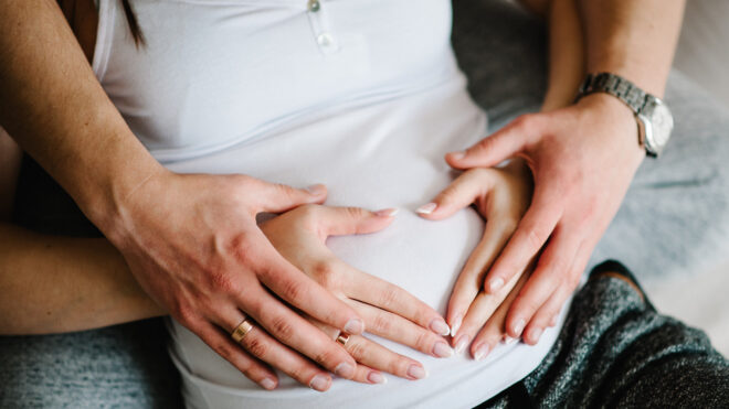 Man puts hands on woman's belly