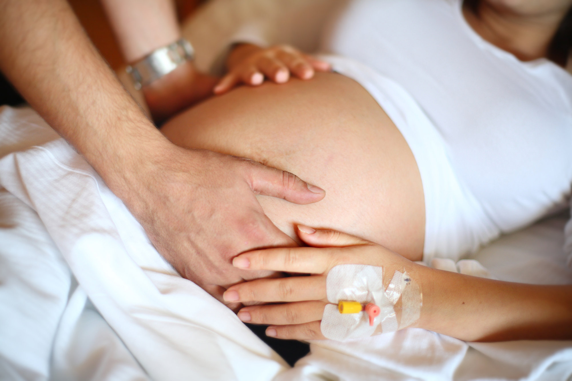 Man has hands on pregnant woman's belly