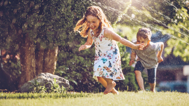 kids running through sprinklers