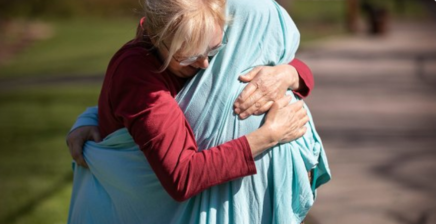 Mom hugs daughter through sheet