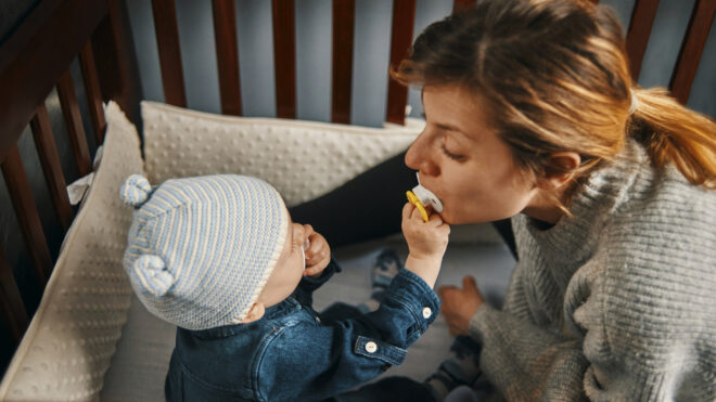 baby in crib swapping pacifier