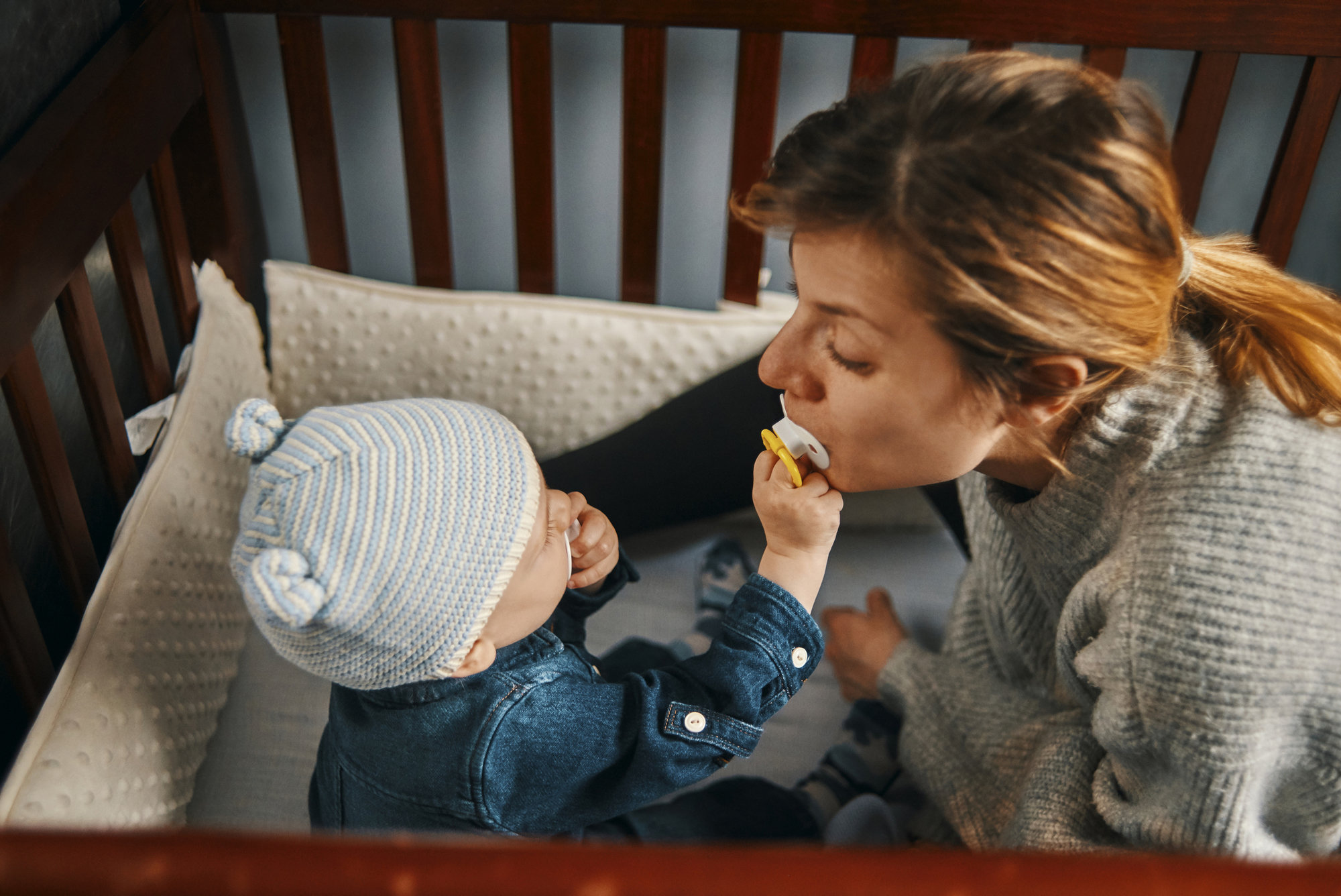 baby in crib swapping pacifier