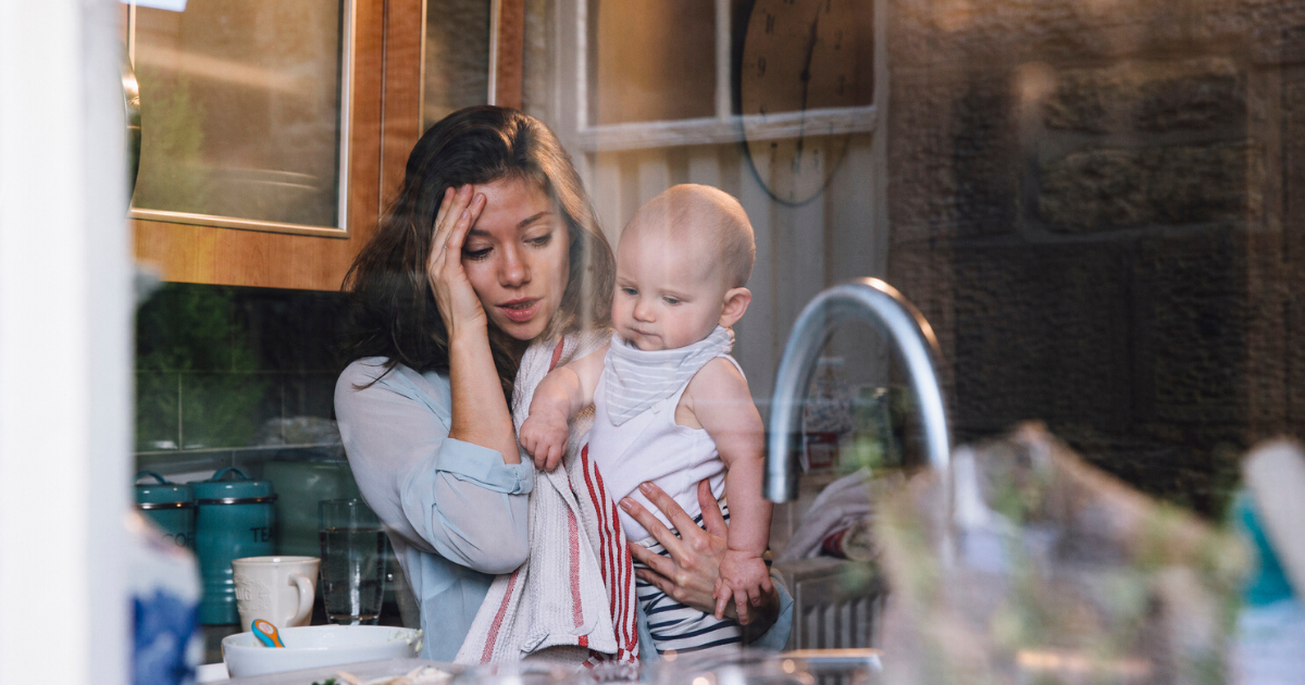 mom frazzled making dinner holding her baby