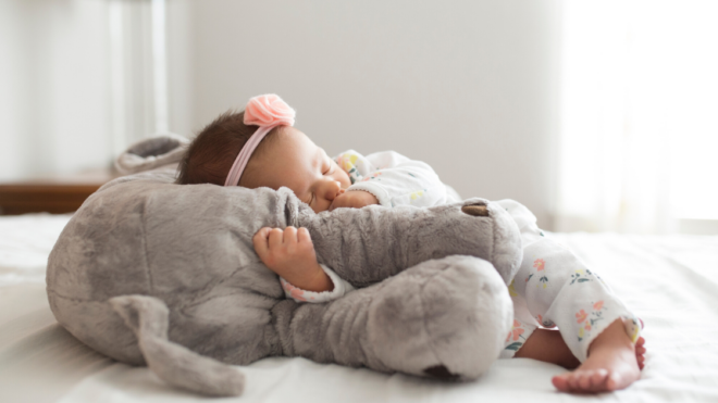 Newborn laying on stuffed elephant