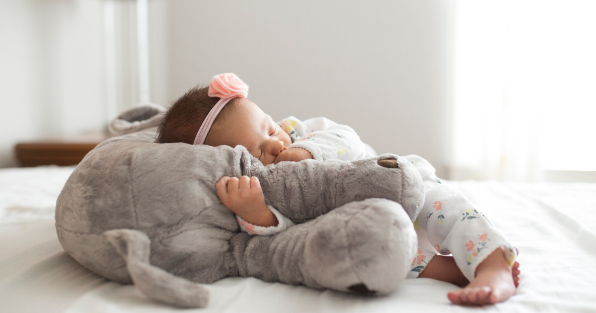 Newborn laying on stuffed elephant