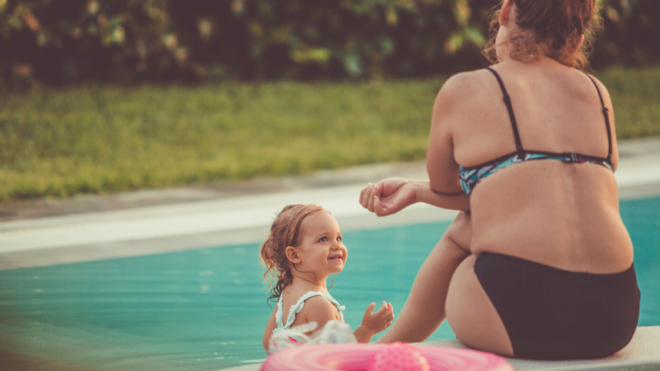 woman in bikini by the pool with a child