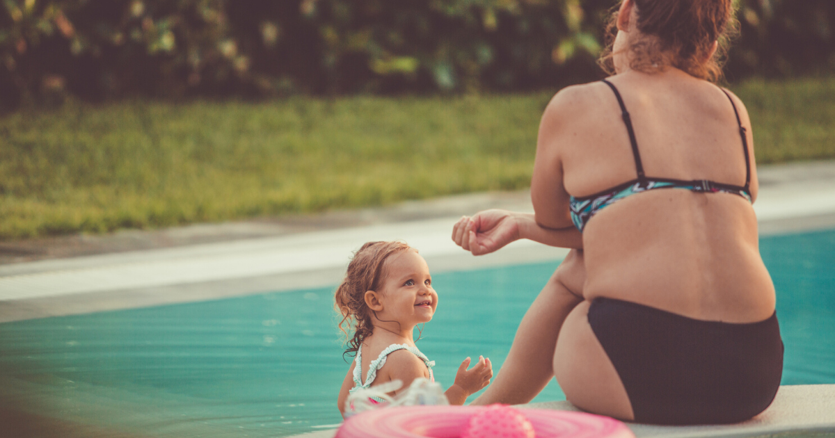 woman in bikini by the pool with a child