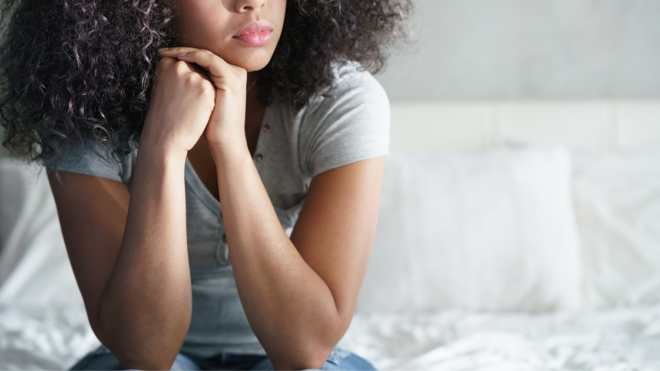 woman sad sitting on her bed