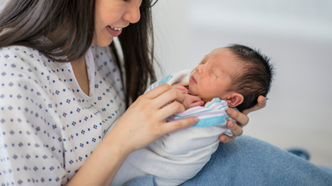 mom holding a newborn baby at the hospital