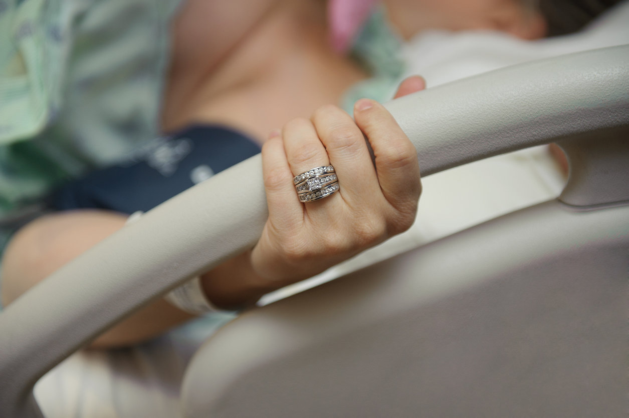 Woman giving birth holding hospital bed