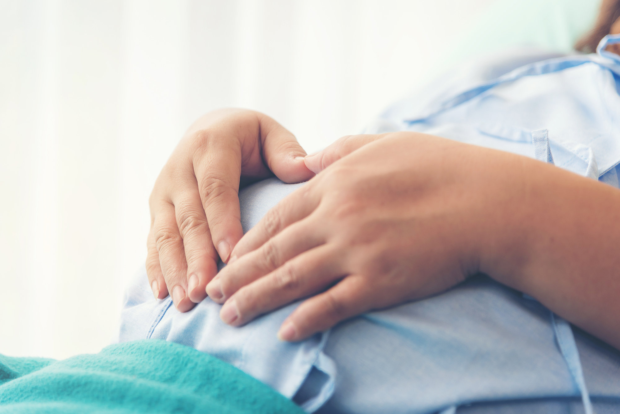 woman with hands on pregnant belly