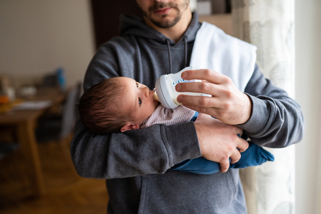 Dad bottle-feeding baby