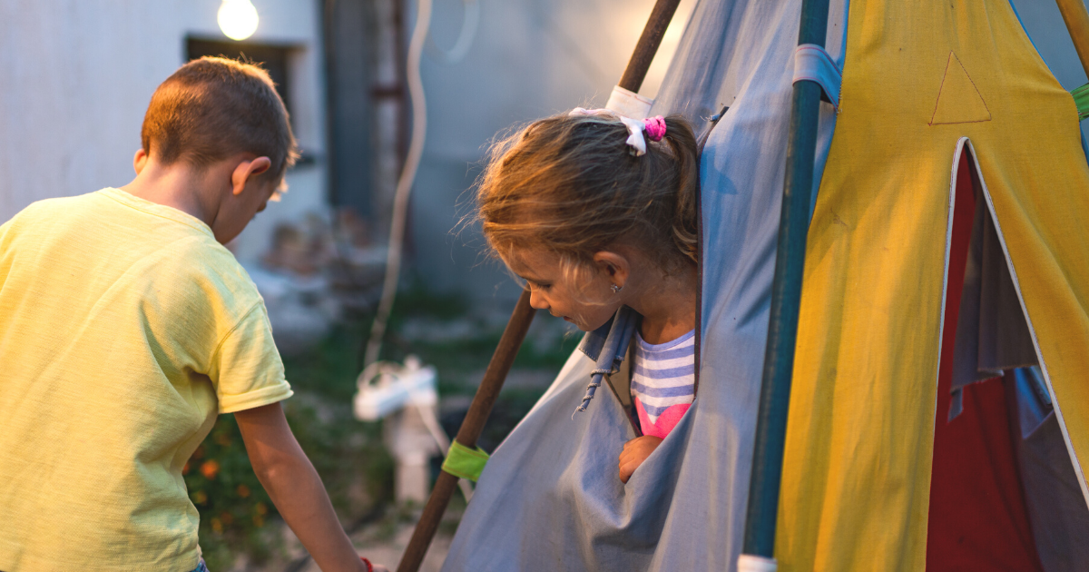 boy and girl in tent in backyard