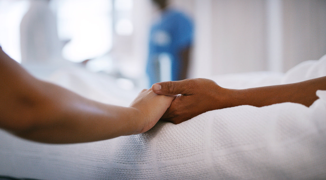 People holding hands from hospital bed