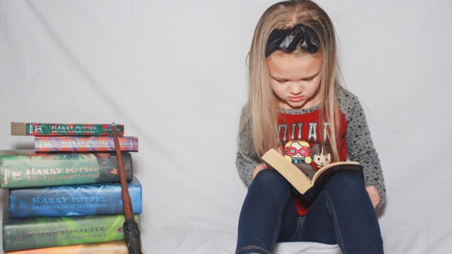 Girl reading Harry Potter books