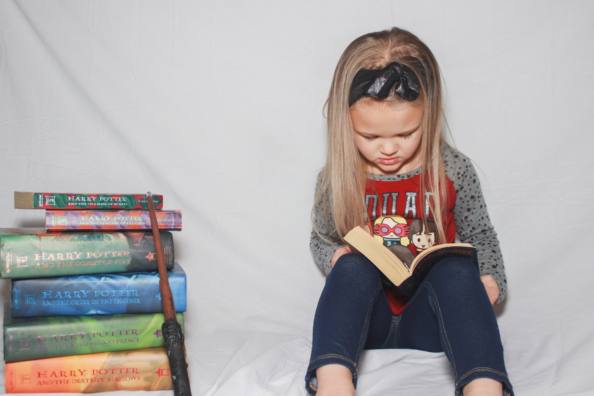 Girl reading Harry Potter books
