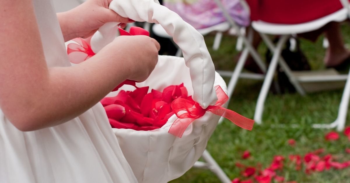 flower girl with red petals in a white basket