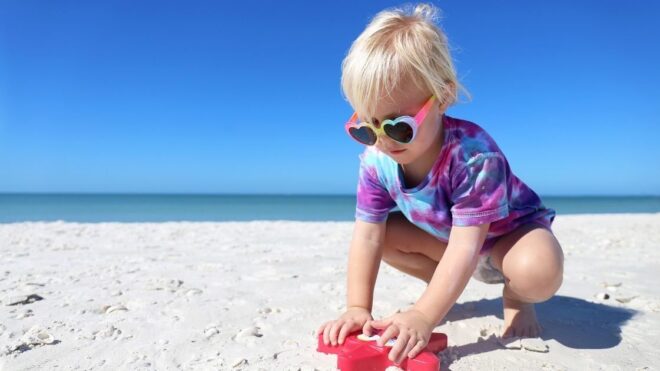 child wearing tie dye shirt at beach