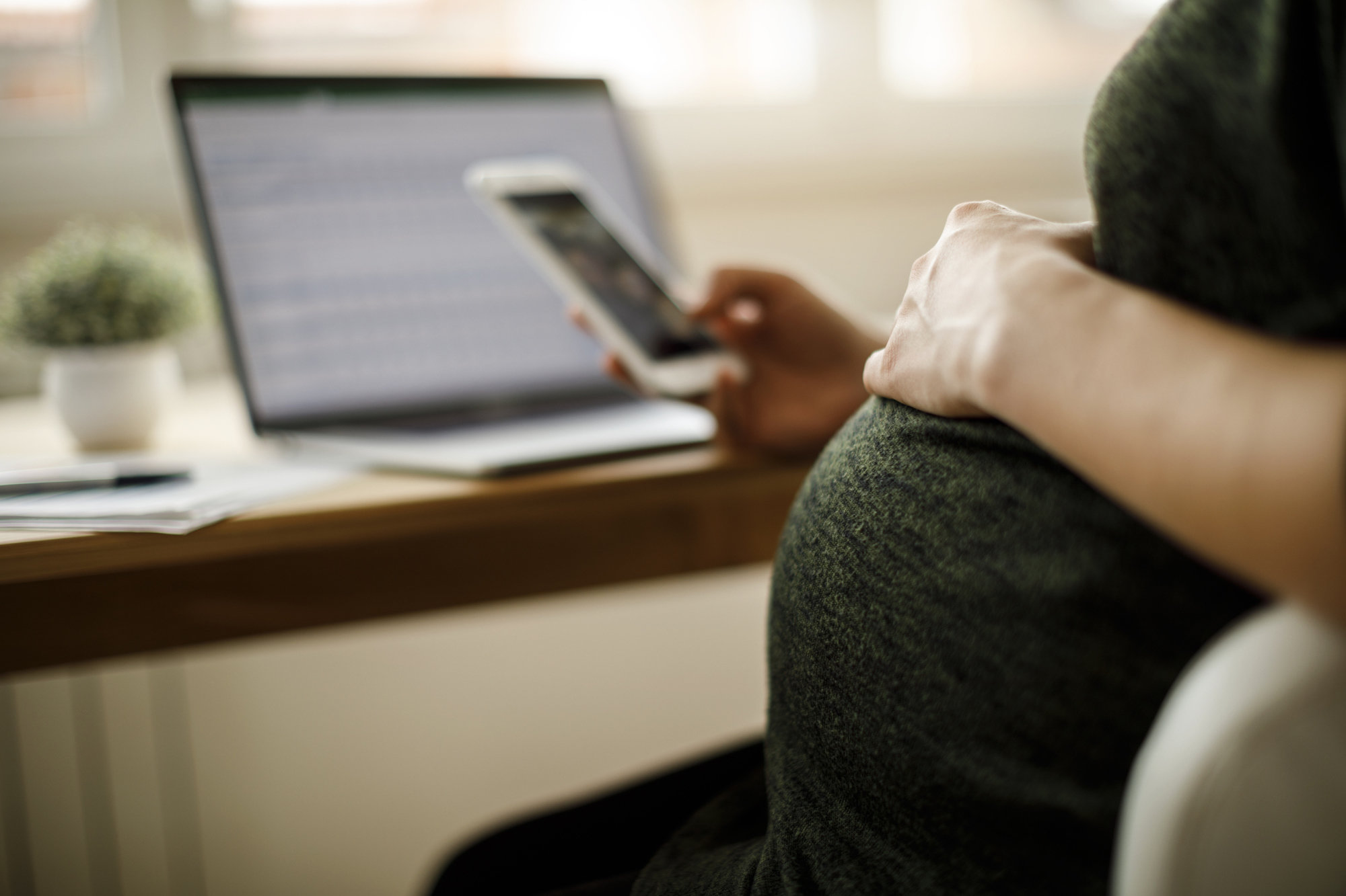 pregnant woman looking at phone