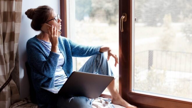 woman on phone looking out the window