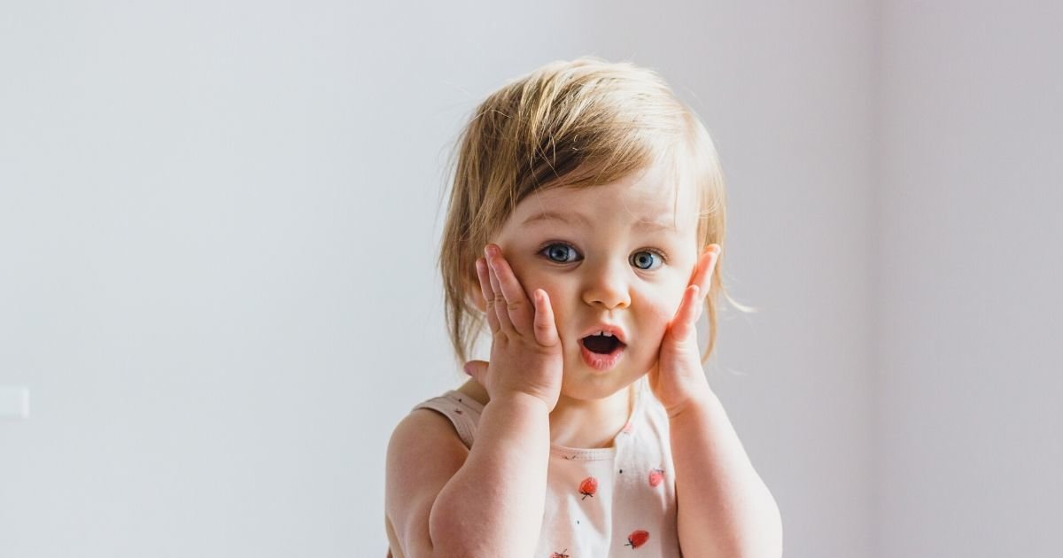 toddler holding hands to cheeks