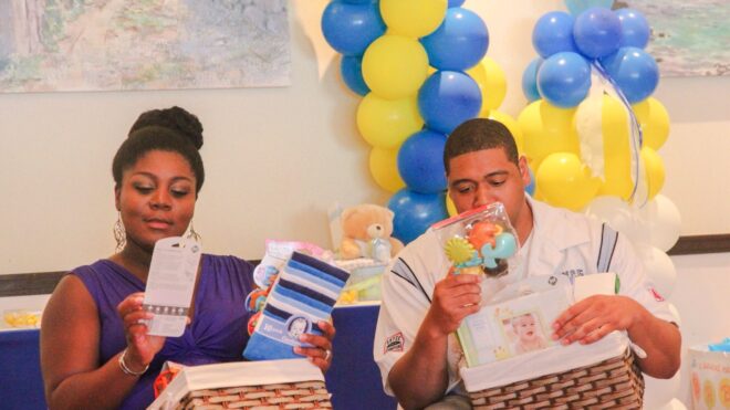 Parents opening gifts at baby shower
