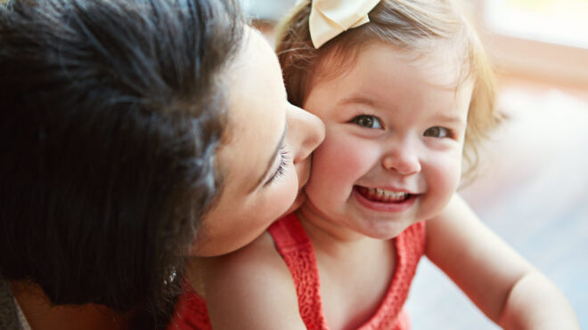 woman kissing toddler