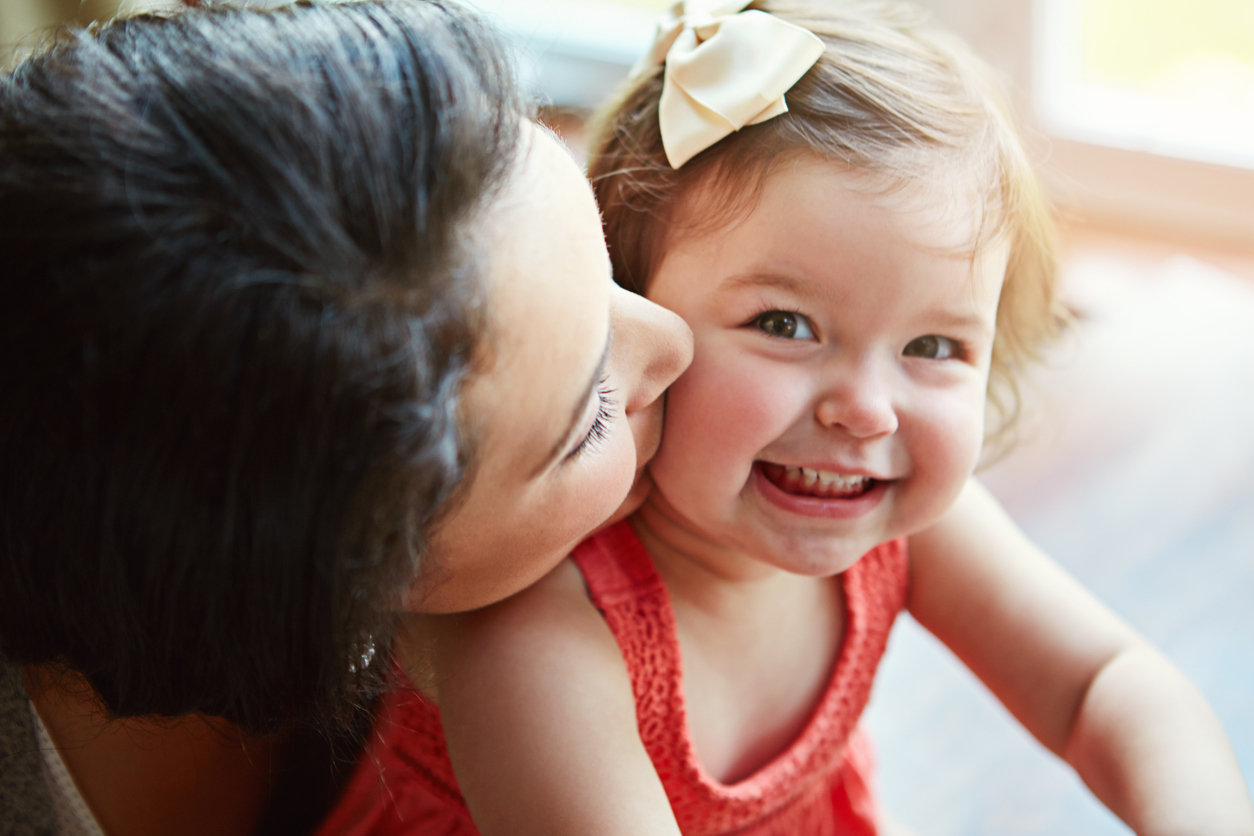 woman kissing toddler