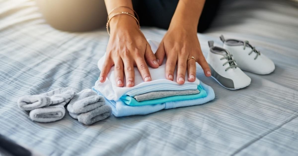 woman folding baby clothes