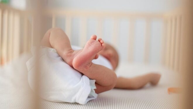 newborn baby sleeping in a crib