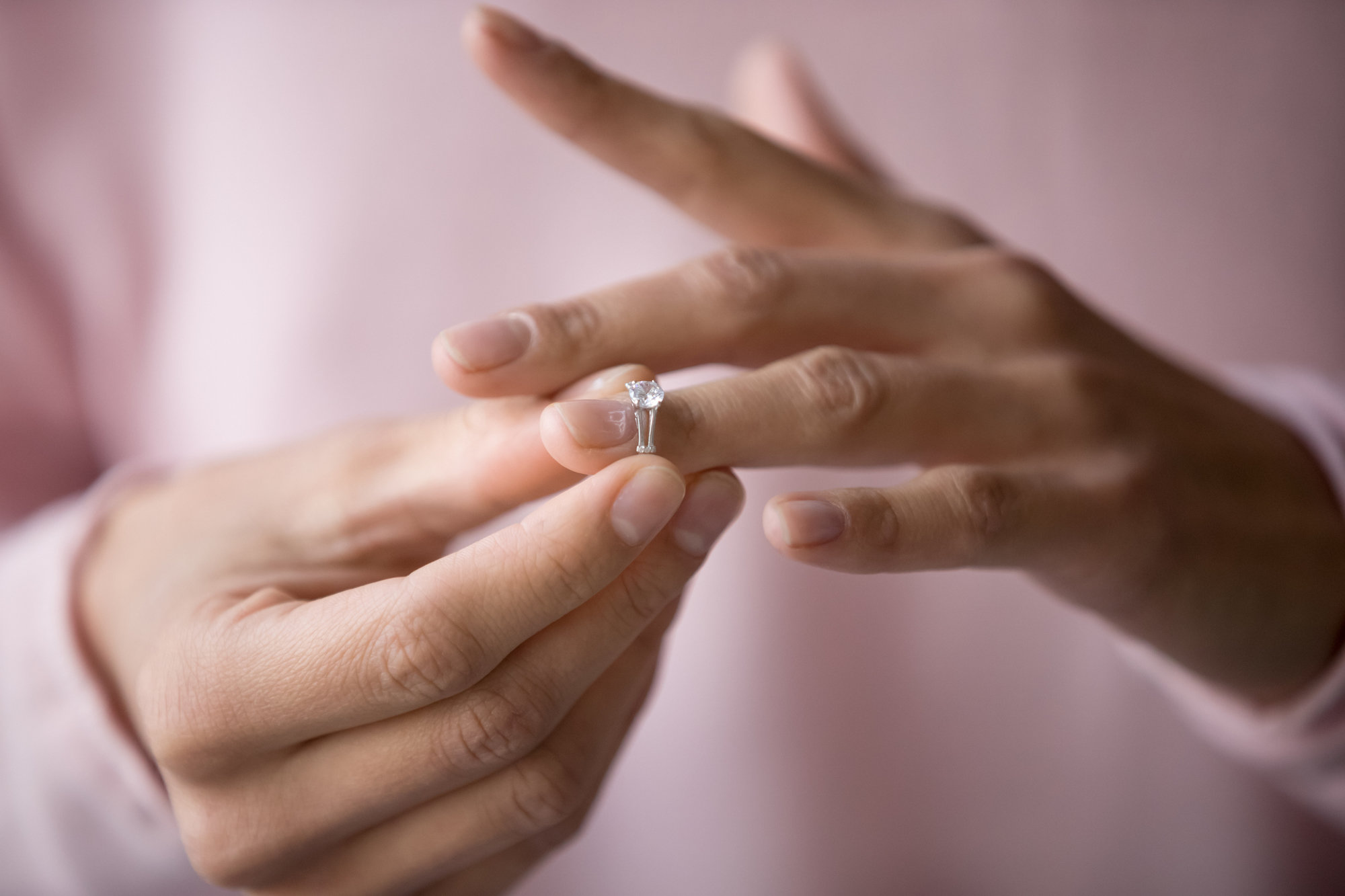 woman taking off diamond engagement ring