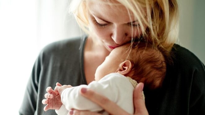 mom cuddling newborn baby