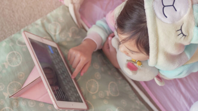 Child wears pajamas on iPad