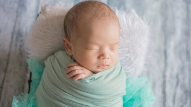 baby boy wrapped in a green blanket