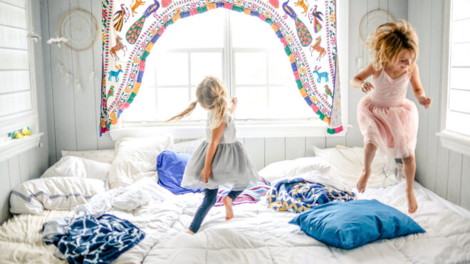 Little girls jumping on bed
