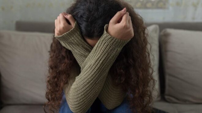 upset woman crossing her arms in front of her face