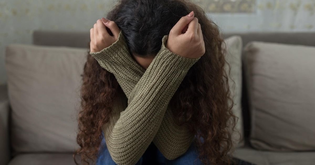upset woman crossing her arms in front of her face