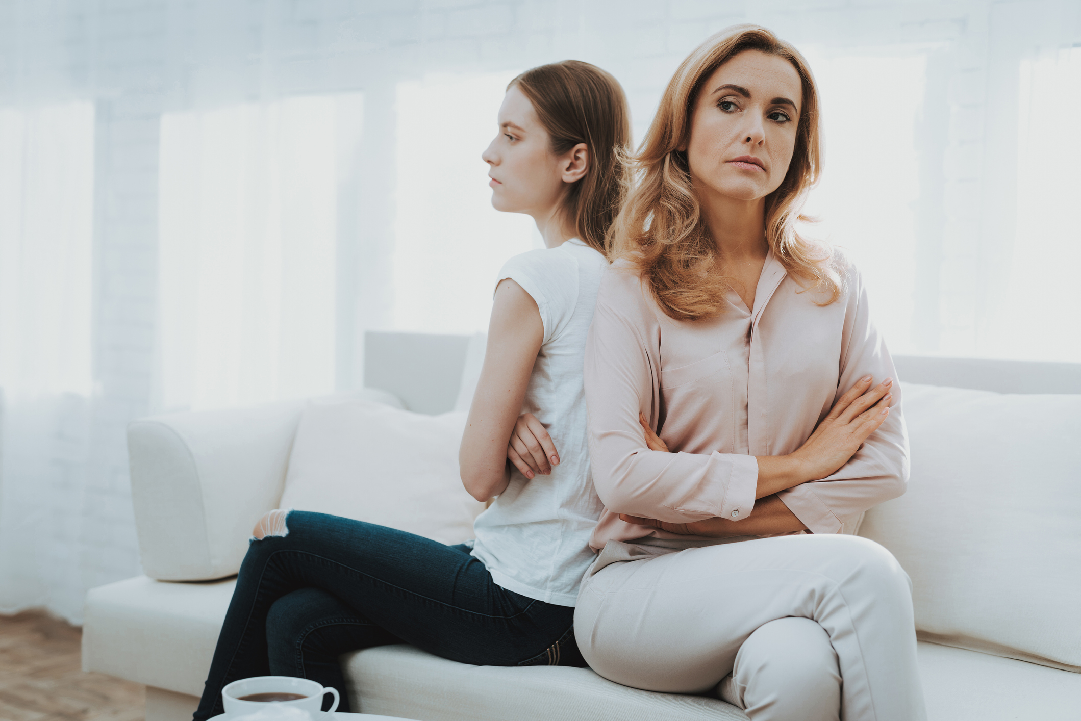 Woman Comforts Unhappy Teenage Daughter at Home.