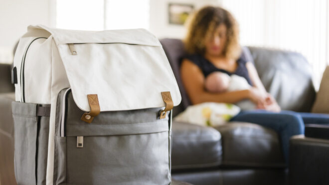 A mother with her newborn baby next to a diaper bag