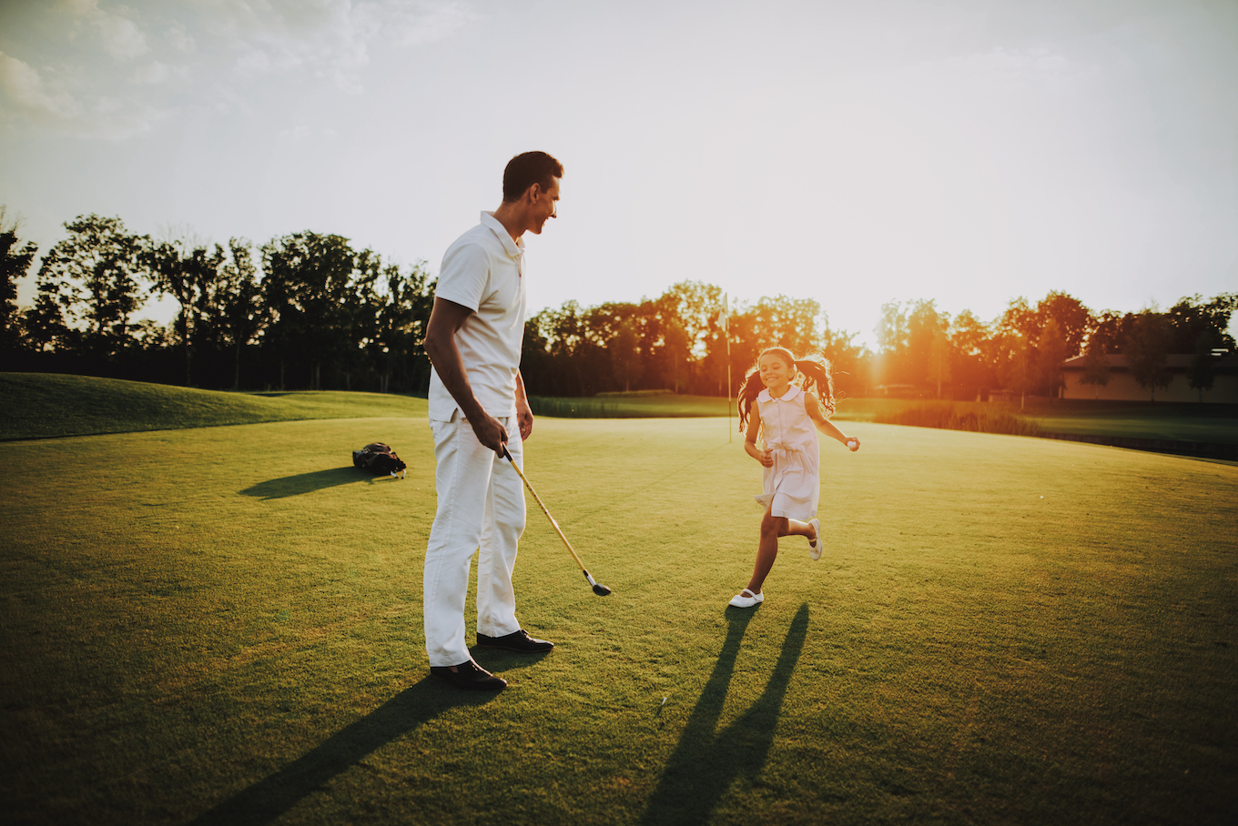 Father Playing Golf with Little Daughter on Field.