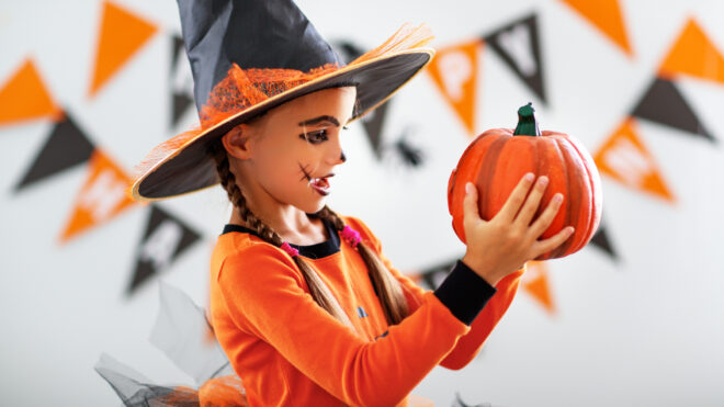 Little girl in halloween decorated room
