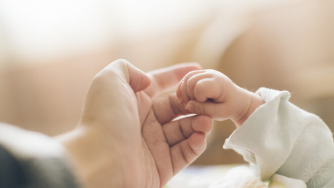 parent touching baby's hand